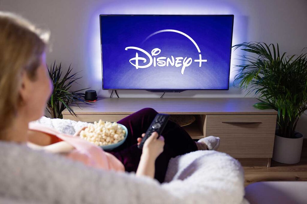 Canadian woman watching TV at home with Disney+ logo on the screen