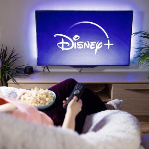 Canadian woman watching TV at home with Disney+ logo on the screen