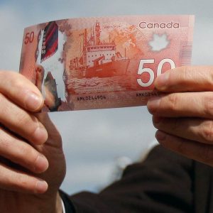 man holding the 50 dollar money from his Canada Workers Benefit