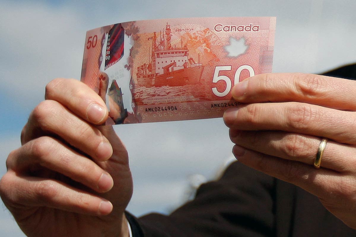 man holding the 50 dollar money from his Canada Workers Benefit