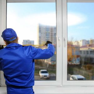 Construction Worker Replacing Window in House