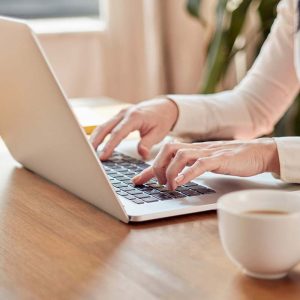 home office working woman typing on laptop