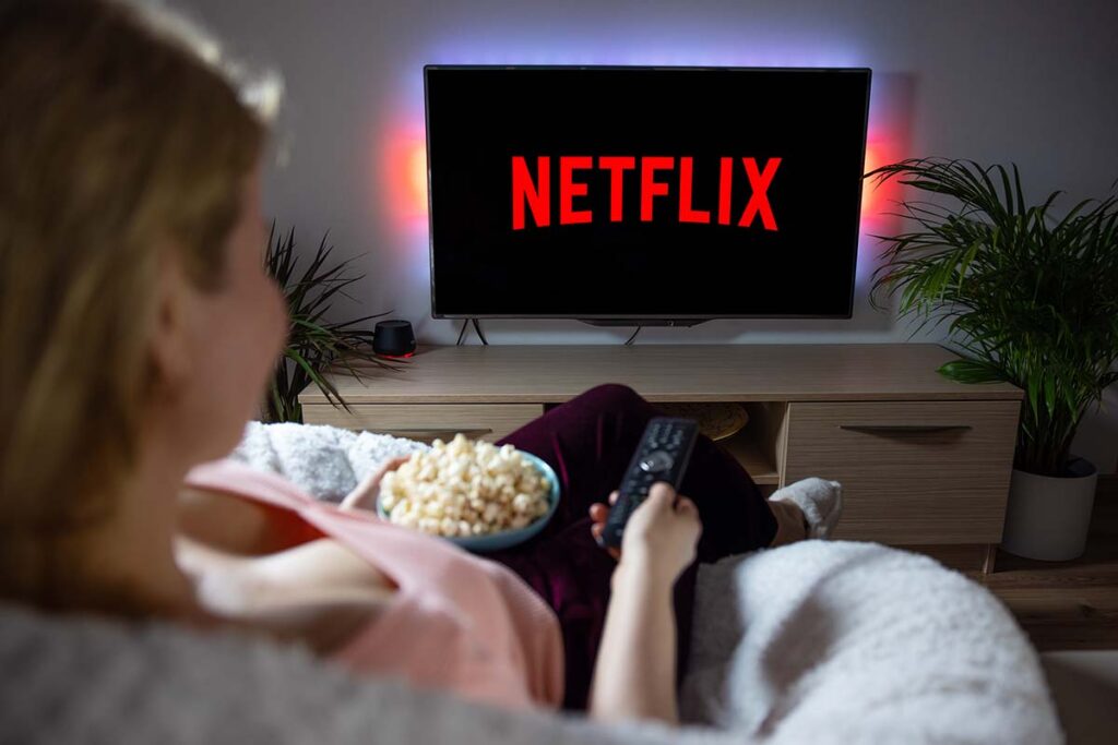 Canadian woman watching TV at home with Netflix logo on the screen