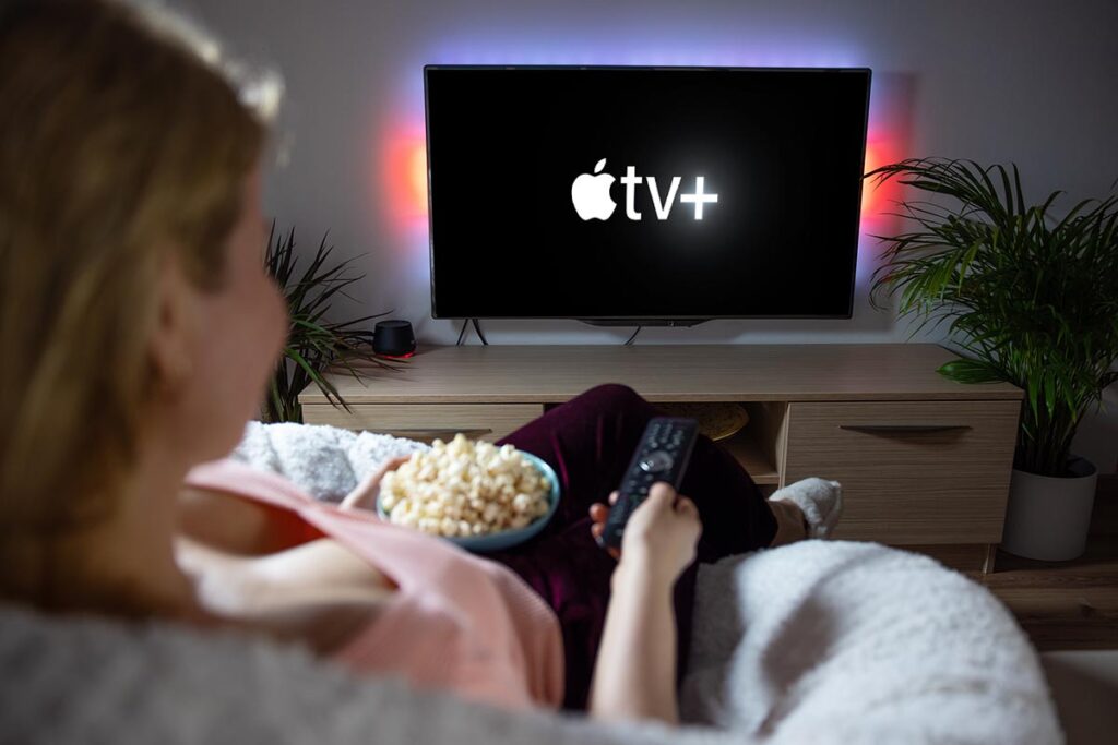 Canadian woman watching TV at home with Apple TV+ logo on the screen