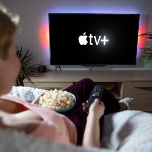 Canadian woman watching TV at home with Apple TV+ logo on the screen