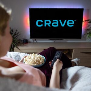 Canadian woman watching TV at home with Crave logo on the screen