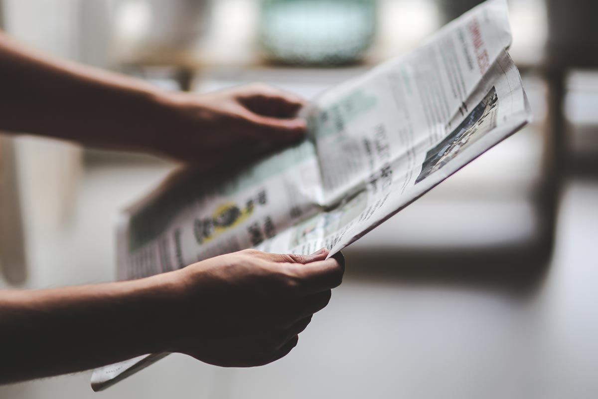 Person searching on newspaper obituaries in Canada