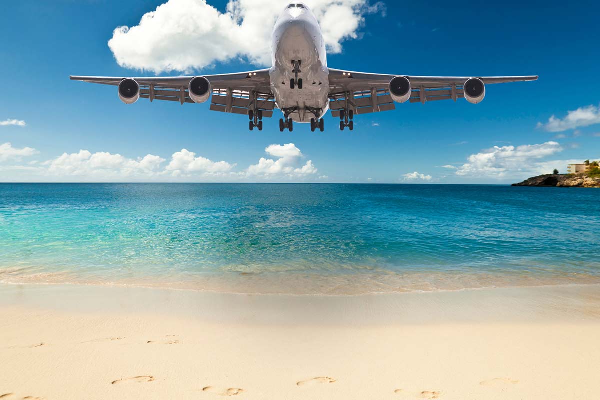 Airplane flying with a beautiful beach background